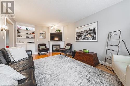 Living room with hardwood / wood-style floors and a textured ceiling - 145 Dragoon Drive, Hamilton, ON - Indoor Photo Showing Living Room With Fireplace