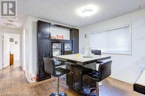 Dining area featuring hardwood / wood-style floors and a textured ceiling - 539 Briarwood Avenue, Listowel, ON - Indoor