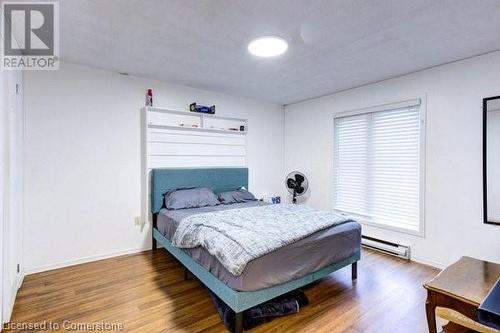 Bedroom featuring hardwood / wood-style floors and a baseboard heating unit - 539 Briarwood Avenue, Listowel, ON - Indoor Photo Showing Bedroom