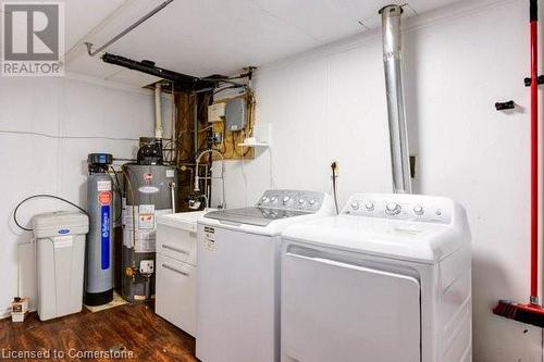 Laundry room featuring dark hardwood / wood-style flooring, separate washer and dryer, and water heater - 539 Briarwood Avenue, Listowel, ON - Indoor Photo Showing Laundry Room