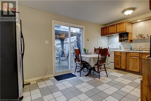 Kitchen with sink, tasteful backsplash, white range with electric cooktop, stainless steel fridge, and light tile patterned floors - 116 Glamis Road, Cambridge, ON - Indoor