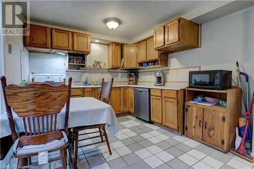 Kitchen with dishwasher, decorative backsplash, light tile patterned floors, and sink - 116 Glamis Road, Cambridge, ON - Indoor Photo Showing Kitchen