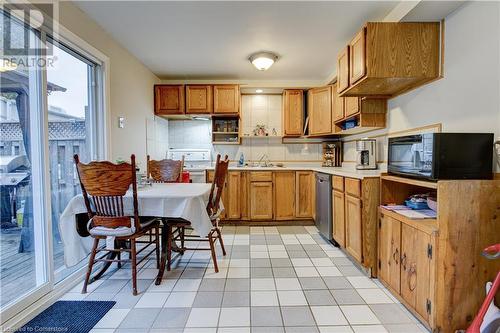 Kitchen featuring white range oven, decorative backsplash, light tile patterned floors, and stainless steel dishwasher - 116 Glamis Road, Cambridge, ON - Indoor Photo Showing Kitchen