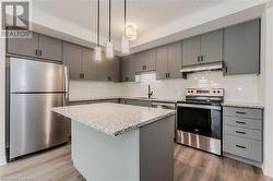 Kitchen featuring sink, light hardwood / wood-style flooring, backsplash, a kitchen island, and appliances with stainless steel finishes - 