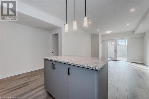 Kitchen featuring gray cabinetry, decorative light fixtures, french doors, and light hardwood / wood-style flooring - 142 Foamflower Place Unit# D053, Waterloo, ON - Indoor