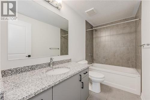 Full bathroom with tiled shower / bath combo, tile patterned flooring, a textured ceiling, toilet, and vanity - 142 Foamflower Place Unit# D053, Waterloo, ON - Indoor Photo Showing Bathroom