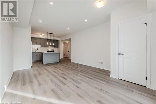 Unfurnished living room featuring light hardwood / wood-style floors and sink - 142 Foamflower Place Unit# D053, Waterloo, ON - Indoor