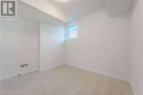 Empty room featuring light carpet - 142 Foamflower Place Unit# D053, Waterloo, ON - Indoor Photo Showing Other Room