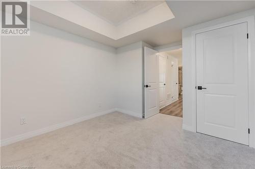 Unfurnished bedroom with light colored carpet - 142 Foamflower Place Unit# D053, Waterloo, ON - Indoor Photo Showing Other Room