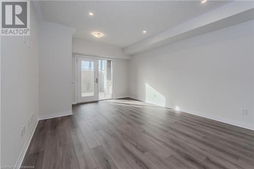 Empty room with hardwood / wood-style floors and french doors - 142 Foamflower Place Unit# D053, Waterloo, ON - Indoor Photo Showing Other Room