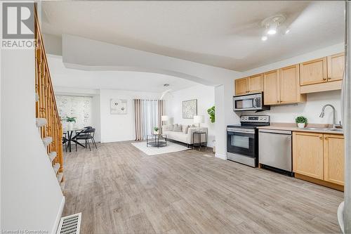 Kitchen featuring sink, light brown cabinets, stainless steel appliances, light hardwood / wood-style flooring, and a textured ceiling - 169 Bismark Drive Unit# 32, Cambridge, ON - Indoor Photo Showing Kitchen