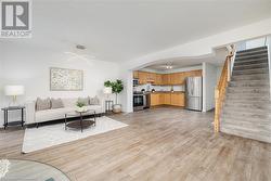 Living room featuring light hardwood / wood-style floors, an inviting chandelier, and sink - 