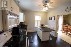 Kitchen with range with electric cooktop, ceiling fan, sink, dark hardwood / wood-style floors, and white cabinetry - 