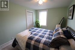 Carpeted bedroom featuring ceiling fan and a closet - 