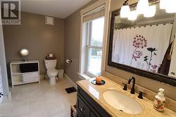 Bathroom featuring tile patterned flooring, vanity, and toilet - 