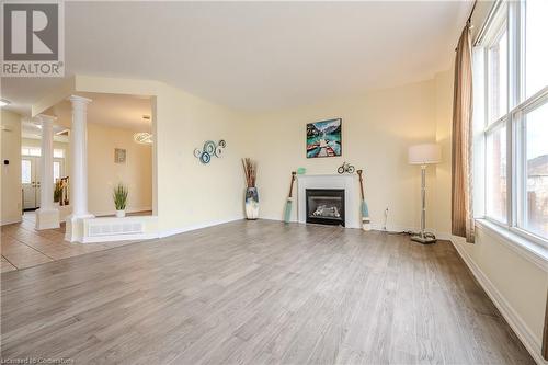 Unfurnished living room featuring ornate columns and light hardwood / wood-style flooring - 584 Winterburg Walk, Waterloo, ON - Indoor Photo Showing Living Room With Fireplace