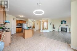 Kitchen with a kitchen bar, backsplash, stainless steel appliances, light tile patterned floors, and decorative light fixtures - 