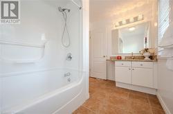 Bathroom with tile patterned flooring, vanity, and washtub / shower combination - 