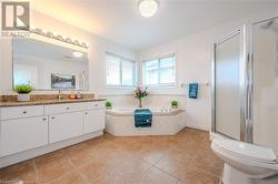 Full bathroom with tile patterned flooring, vanity, toilet, and plus walk in shower - 