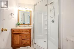 Bathroom with tile patterned floors, vanity, toilet, and a shower with door - 