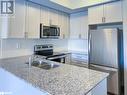 Kitchen with kitchen peninsula, stainless steel appliances, white cabinetry, and sink - 1581 Rose Way Unit# 513, Milton, ON  - Indoor Photo Showing Kitchen With Stainless Steel Kitchen With Double Sink With Upgraded Kitchen 