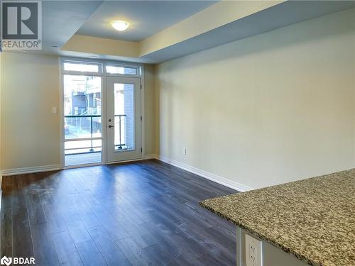 Entryway with plenty of natural light, french doors, dark wood-type flooring, and a tray ceiling - 1581 Rose Way Unit# 513, Milton, ON - Indoor Photo Showing Other Room