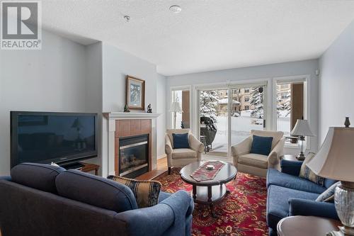 2101, 303 Arbour Crest Drive Nw, Calgary, AB - Indoor Photo Showing Living Room With Fireplace