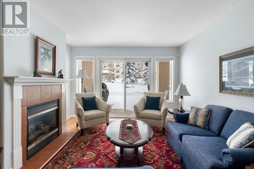 2101, 303 Arbour Crest Drive Nw, Calgary, AB - Indoor Photo Showing Living Room With Fireplace