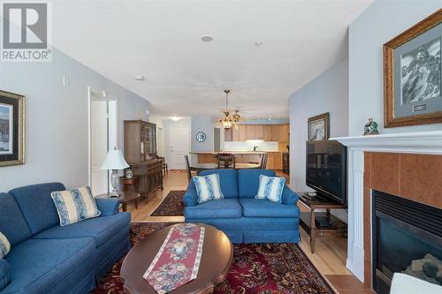 2101, 303 Arbour Crest Drive Nw, Calgary, AB - Indoor Photo Showing Living Room With Fireplace