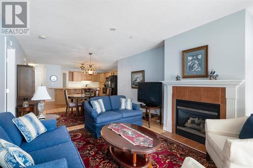 2101, 303 Arbour Crest Drive Nw, Calgary, AB - Indoor Photo Showing Living Room With Fireplace