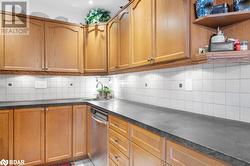 Kitchen featuring stainless steel dishwasher, decorative backsplash, and sink - 