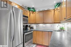 Kitchen featuring decorative backsplash, sink, and appliances with stainless steel finishes - 