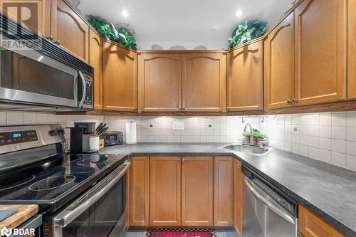 Kitchen with decorative backsplash, sink, and appliances with stainless steel finishes - 35 Albion Street Unit# 37, Belleville, ON - Indoor Photo Showing Kitchen