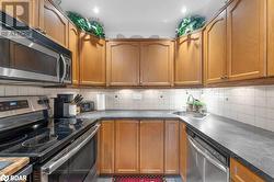 Kitchen with decorative backsplash, sink, and appliances with stainless steel finishes - 