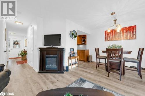 Living room with light hardwood / wood-style floors and an inviting chandelier - 35 Albion Street Unit# 37, Belleville, ON - Indoor With Fireplace