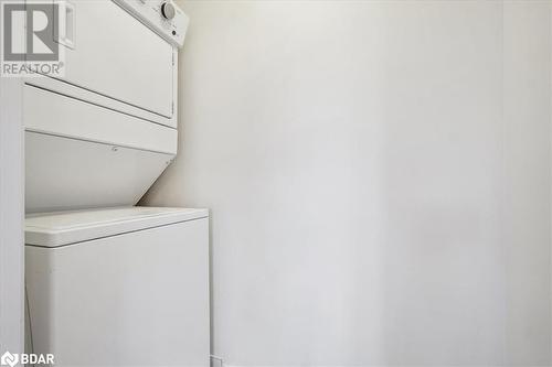 Laundry room featuring stacked washer and clothes dryer - 1569 Rose Way Unit# 104, Milton, ON - Indoor Photo Showing Laundry Room