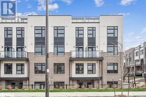 View of building exterior - 1569 Rose Way Unit# 104, Milton, ON - Outdoor With Balcony With Facade