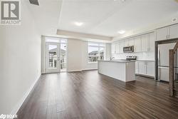 Kitchen with appliances with stainless steel finishes, backsplash, a kitchen island with sink, sink, and dark hardwood / wood-style floors - 