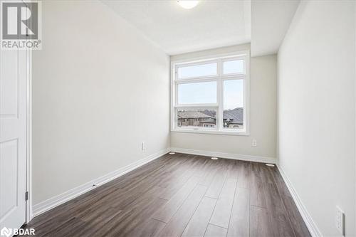 Empty room featuring dark hardwood / wood-style floors - 1569 Rose Way Unit# 104, Milton, ON - Indoor Photo Showing Other Room