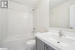 Full bathroom featuring tiled shower / bath, vanity, and toilet - 