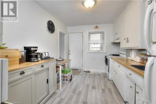 Kitchen with a textured ceiling, white cabinets, light hardwood / wood-style floors, and white appliances - 524 Krug Street, Kitchener, ON - Indoor Photo Showing Kitchen