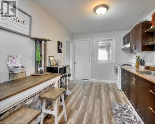 Kitchen with light wood-type flooring, dark brown cabinetry, white range with electric stovetop, and sink - 524 Krug Street, Kitchener, ON - Indoor Photo Showing Kitchen