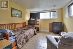 Tiled bedroom with multiple windows and a textured ceiling - 