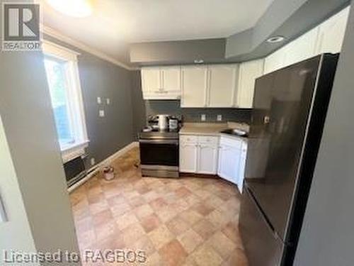 Kitchen featuring black fridge, white cabinets, stainless steel electric range oven, and ornamental molding - 745 4Th Avenue East Avenue, Owen Sound, ON 