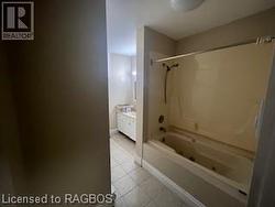 Bathroom featuring bathtub / shower combination, vanity, and tile patterned flooring - 