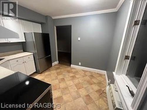 Kitchen featuring white cabinets, black range, crown molding, and stainless steel refrigerator - 745 4Th Avenue East Avenue, Owen Sound, ON 