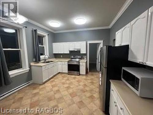 Kitchen featuring white cabinets, sink, crown molding, and stainless steel range - 745 4Th Avenue East Avenue, Owen Sound, ON 