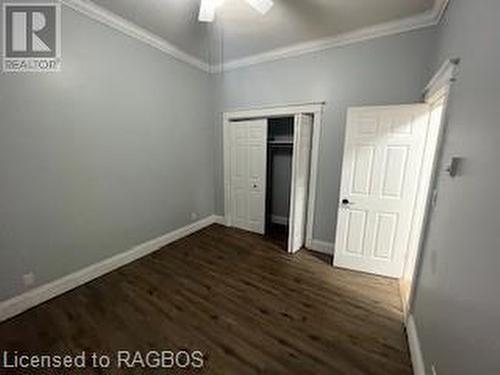 Unfurnished bedroom featuring ornamental molding, a closet, ceiling fan, and dark wood-type flooring - 745 4Th Avenue East Avenue, Owen Sound, ON 