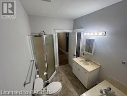 Bathroom with vanity, toilet, an enclosed shower, and wood-type flooring - 