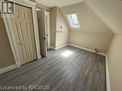 Bonus room with dark hardwood / wood-style flooring and lofted ceiling with skylight - 